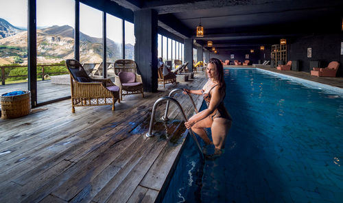 Side view of mid adult woman in swimming pool at tourist resort