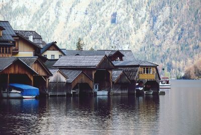 Houses by river against mountain