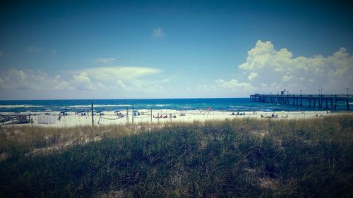 Scenic view of beach against cloudy sky