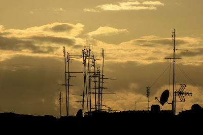 Silhouette electricity pylon against sky during sunset