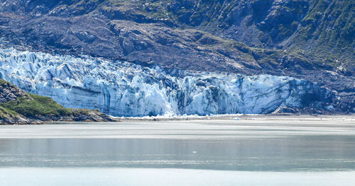 Ancient glacier and foggy dramatic sky in alaska ocean bay