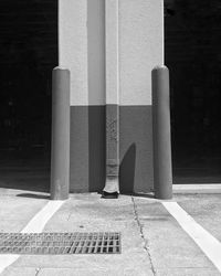 Close-up of metallic structure on footpath by building