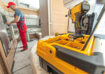 Close-up of tool with man working in background