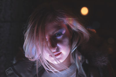 Close-up portrait of young woman at night