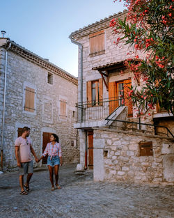 Full length rear view of woman walking against building