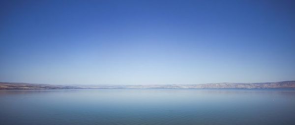 Calm sea against clear blue sky