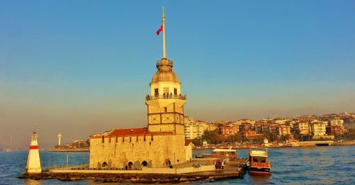 View of lighthouse in city against clear sky