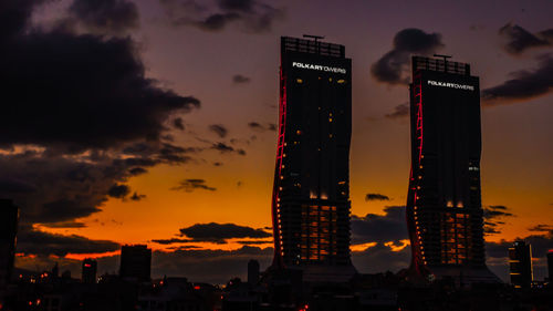 Illuminated buildings against sky during sunset