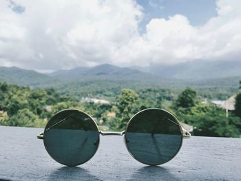 Sunglasses on mountain against sky