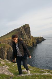Full length of man standing on rock against sky
