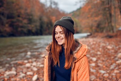 Portrait of smiling young woman standing during autumn