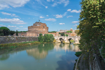 Arch bridge over river against buildings