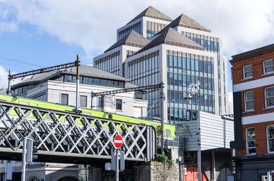 Low angle view of railway bridge against modern buildings