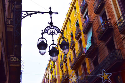 Low angle view of illuminated street light against building