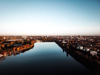 High angle view of buildings by river in town against sky