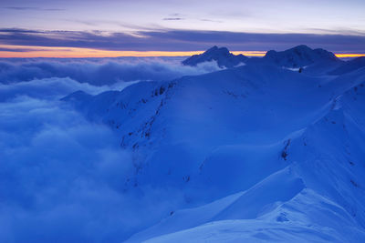 Scenic view of snowcapped mountains against sky during sunset