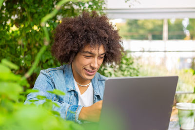 Portrait of woman using laptop at park