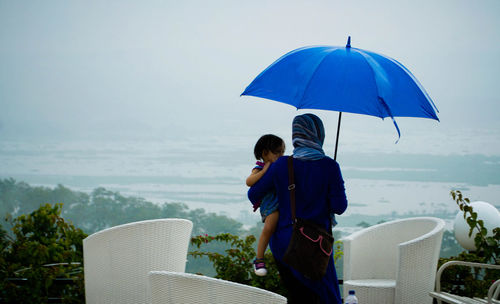 Rear view of people looking at sea against sky
