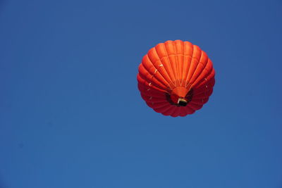 Low angle view of umbrella against clear blue sky