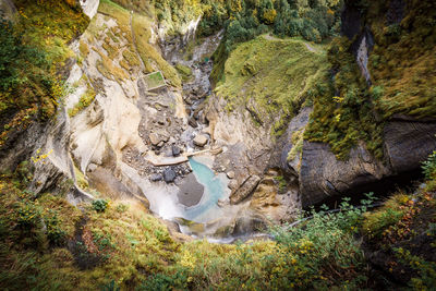 High angle view of stream flowing through rocks in forest