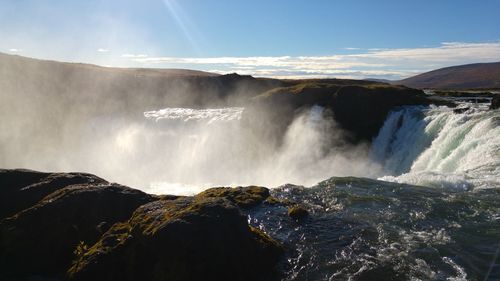 Panoramic view of waterfall against sky