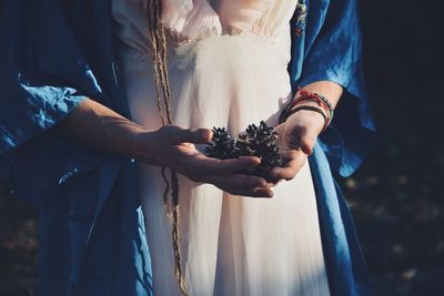 Midsection of couple holding hands