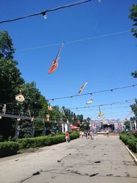 People on street against clear blue sky