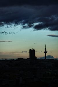 Silhouette of buildings against cloudy sky