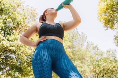 Low angle view of woman exercising in park