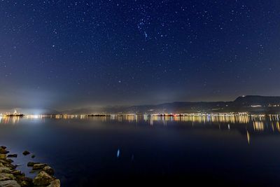 Scenic view of lake against sky at night