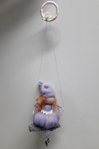 Close-up of girl with toy hanging against wall