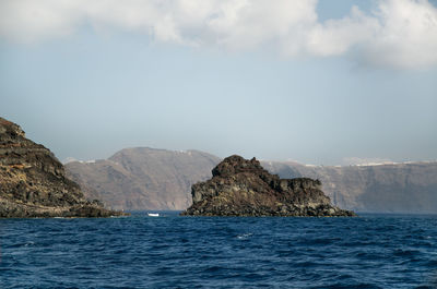 Scenic view of sea and mountains against sky