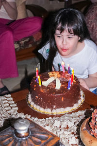 High angle view of girl blowing candle during birthday