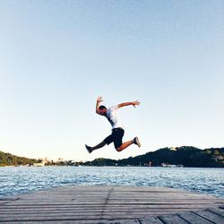 Full length of woman jumping in water