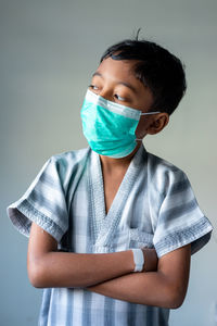 Portrait of boy wearing mask against white background