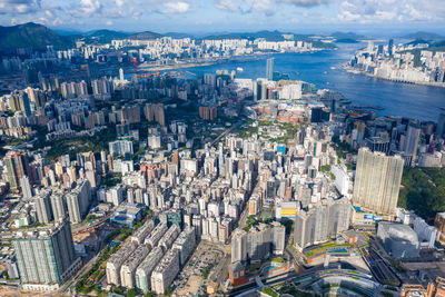 High angle view of city buildings against cloudy sky