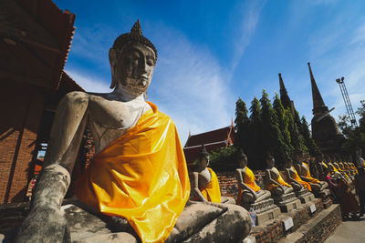 Statue against temple and building against sky