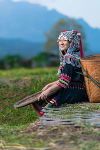 Woman wearing hat while sitting on field