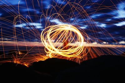 Close-up of illuminated lighting against sky at night.