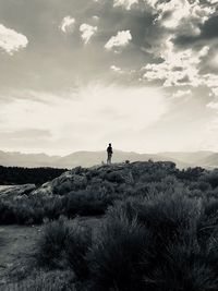 Person standing on land against sky