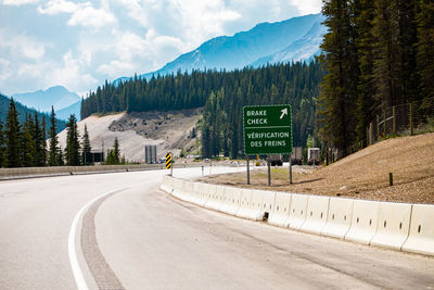 Road by mountains against sky in city