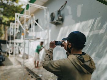 Rear view of man photographing