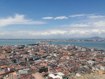 High angle view of townscape by sea against sky