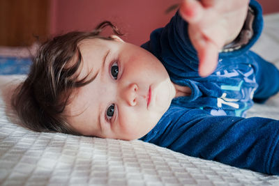 Portrait of cute baby girl on bed at home