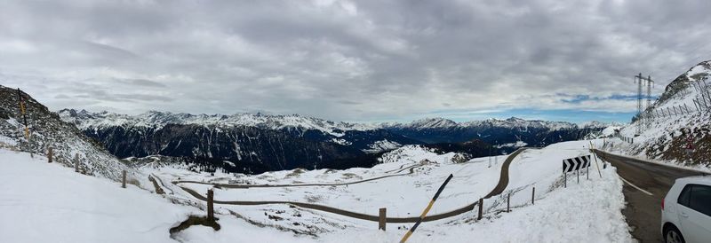 Scenic view of snow covered mountains against cloudy sky