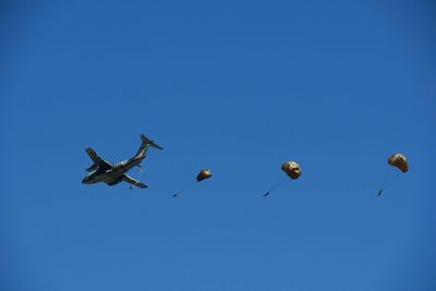 Low angle view of kite flying against blue sky