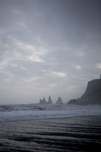 Scenic view of calm sea against cloudy sky