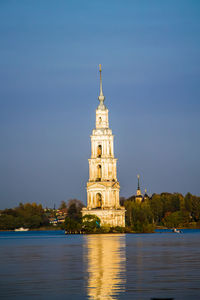 Beautiful christian church with golden domes among green trees.