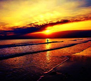 Scenic view of sea against dramatic sky during sunset