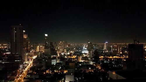 Illuminated cityscape against sky at night